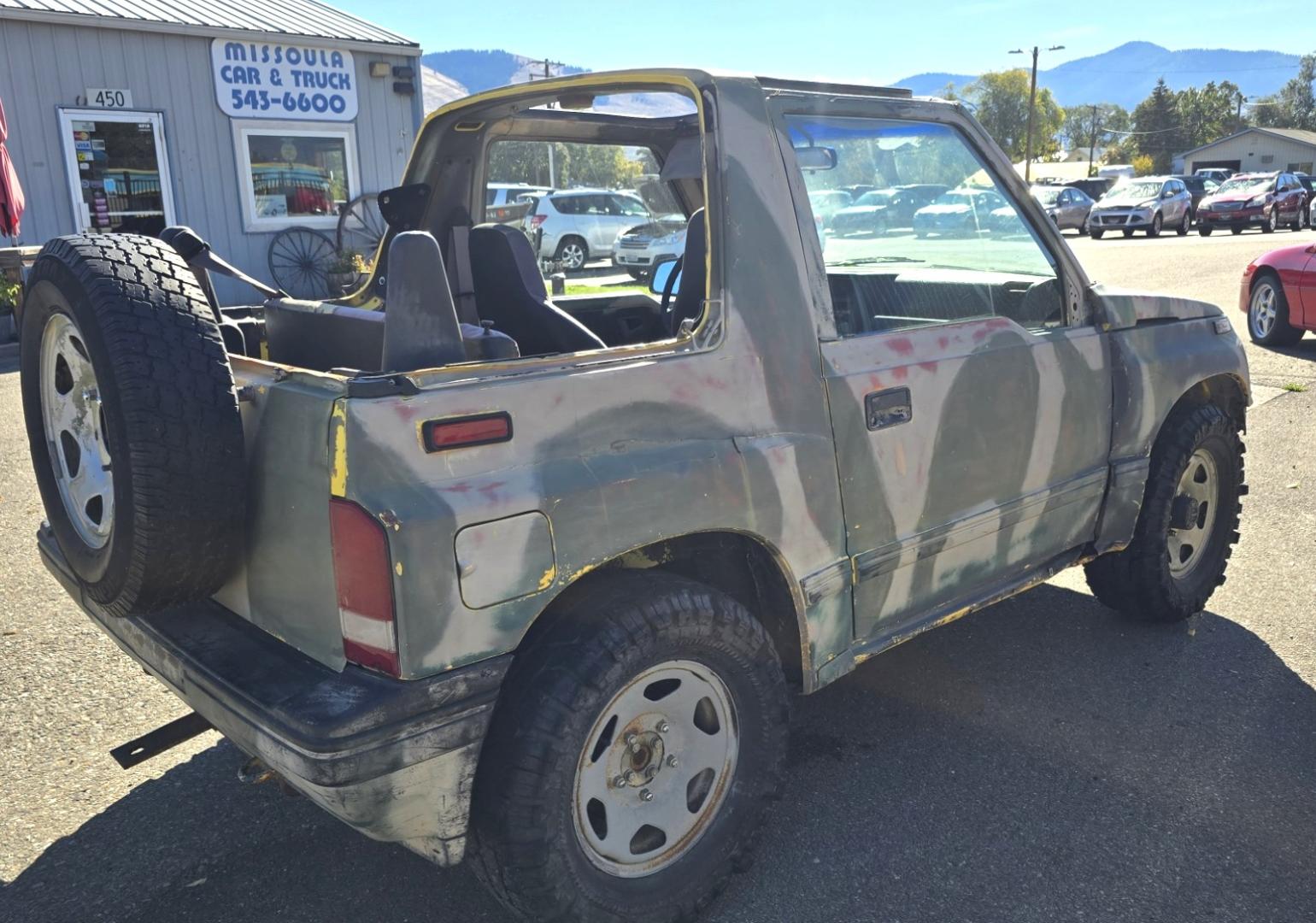 1993 Camo Geo Tracker 2-Door 4WD (2CNBJ18U7P6) with an 1.6L L4 SOHC 8V engine, 4 Speed Manual transmission, located at 450 N Russell, Missoula, MT, 59801, (406) 543-6600, 46.874496, -114.017433 - One Owner with only 34K Miles. Not the prettiest but runs amazing. Owner bought it to keep at his cabin it it has very little use. Somewhere along the way he lost the top to it. 1.6L I4 Engine. 4 Speed Manual Transmission. 4WD. Seats Five. More comfortable than an ATV with similar attributes. B - Photo#4