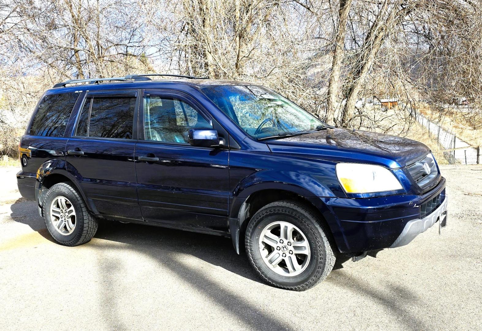 2004 Blue /Black Honda Pilot EX w/ Leather and DVD (2HKYF18664H) with an 3.5L V6 SOHC 24V engine, 5-Speed Automatic Overdrive transmission, located at 450 N Russell, Missoula, MT, 59801, (406) 543-6600, 46.874496, -114.017433 - Great Running AWD Honda. 3.5L V6 Engine. 3rd Row Seating. Heated Front Seats. Power Drivers Seat. Rear Entertainment. Air. Cruise. Tilt. Power Windows and Locks. Remote Start. Has some rust and the front seats are worn. Has an Air Bag Light so we are selling AS-IS. Clean Title and Carfax. No Fina - Photo#4